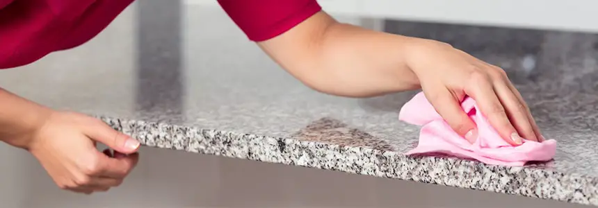 Woman Cleaning Granite Countertop